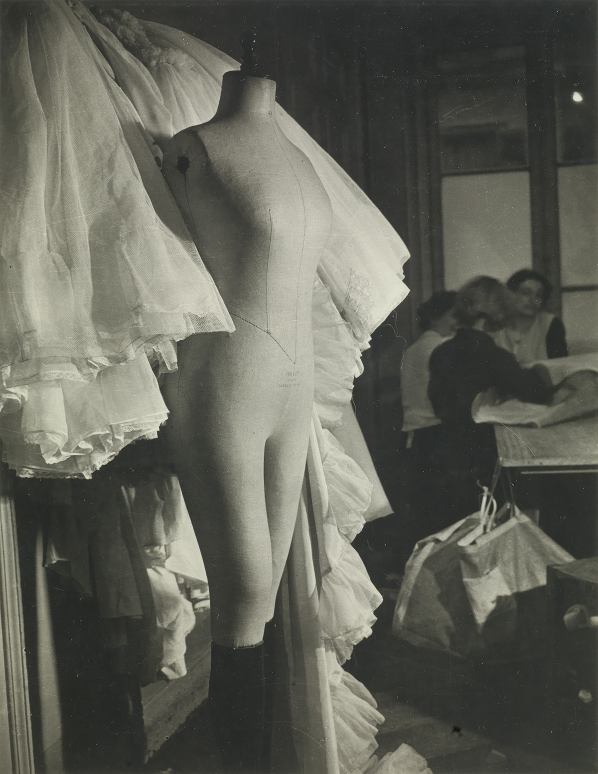 BRASSAÏ (1899-1984) Mannequin and workers in dress shop, Paris.